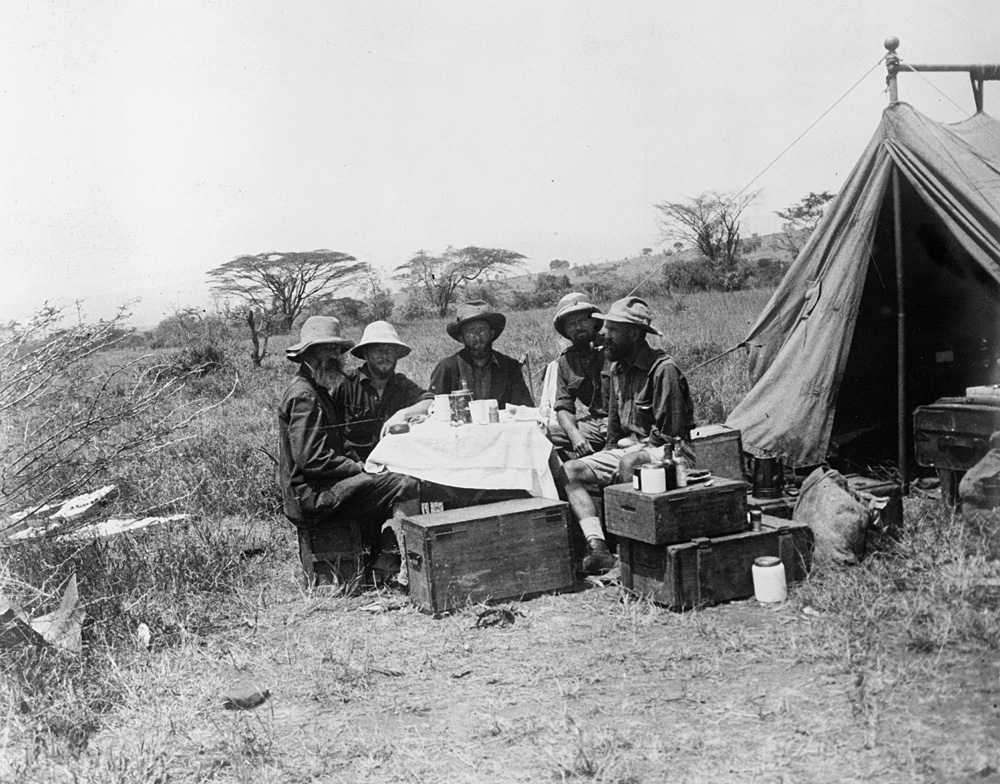 People gathered around a tent in a camp site